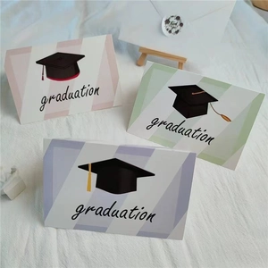 Graduation greeting card set with mortarboard illustrations and envelopes on white fabric