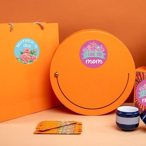 Close-up of Happy Mother's Day floral stickers used on orange gift bags and boxes