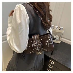 Detailed close-up of dark brown vintage faux leather shoulder bag with silver metal studs