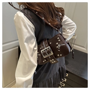 Detail of dark brown Y2K baguette bag with silver studs and oversized metal buckle