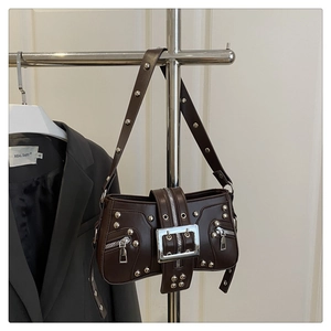 Detail of dark brown vintage punk shoulder bag with silver rivets and metal buckle
