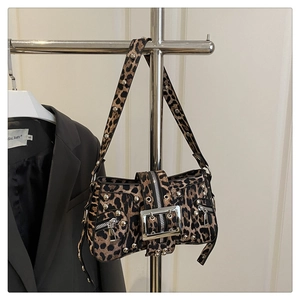 Close-up of leopard print shoulder bag with silver studs and large metal buckle detail