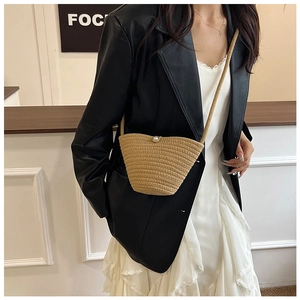 Detailed close-up of handmade beige woven bucket bag with elegant pearl button closure
