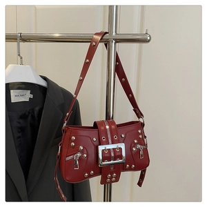 Detail of red vintage biker bag with silver rivets and metal buckle hardware