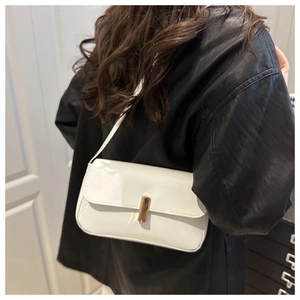 Detail of white patent leather baguette bag with a sleek gold metal buckle closure
