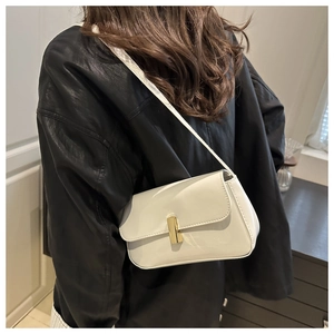 Detailed view of white patent leather square bag with golden buckle on a model