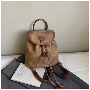 Detail of vintage suede backpack with metal buckle and drawstring on stylish background