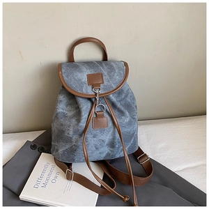 Detail of vintage canvas backpack with leather trim and adjustable drawstring straps