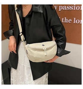 Detail of beige crescent crossbody bag with embroidery logo and adjustable strap