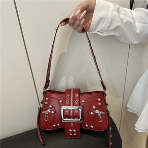 Y2K vintage red shoulder bag with silver studs and polished buckles in a hand-held view