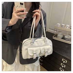 Detail of white PU leather bowling bag showing front pockets and buckle straps