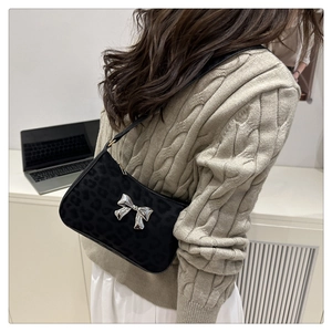 Detail of black leopard jacquard shoulder bag with a silver butterfly buckle