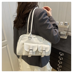 Detail of white glossy bowling bag with silver buckles worn over the shoulder