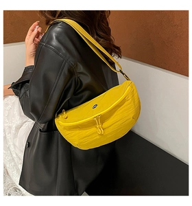 Detail view of bright yellow crescent crossbody bag with adjustable nylon shoulder strap