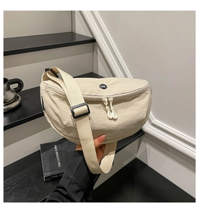 Detail of cream nylon saddle bag with circular OK patch and adjustable wide strap