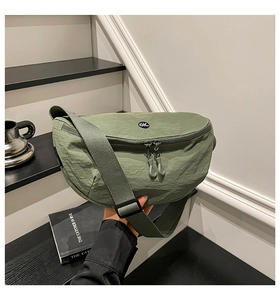 Detail of olive green nylon saddle bag featuring dual zippers and circular logo on front