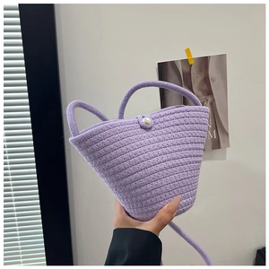 Detail of lavender woven bucket bag featuring elegant pearl clasp and handle