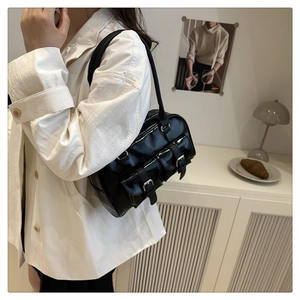 Close-up of black glossy bowling bag with two front flap pockets and metallic buckles