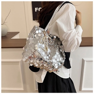 Close-up of silver sequin shoulder bag with decorative pearl charm and metallic strap