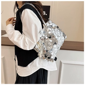 Detail of silver sequin bucket bag with pearl charm and metallic chain strap