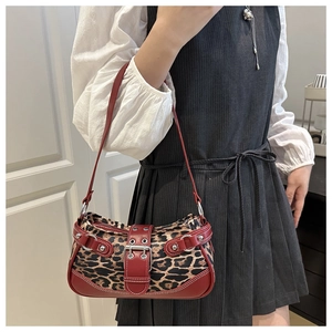 Detail of leopard print crescent bag with red leather trim and silver metal buckle