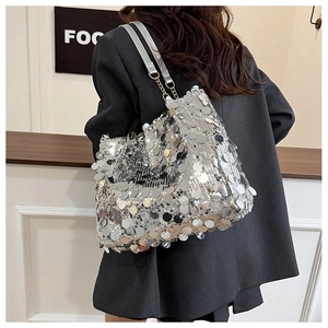 Détail du sac cabas à paillettes argentées avec chaînes porté par un mannequin