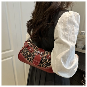 Detail of leopard print shoulder bag with red leather trim and silver metal buckle