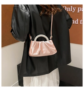 Detail of light pink satin pleated cloud bag with elegant pearl beaded handle