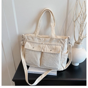 Detail view of large corduroy tote bag with front pockets and adjustable strap