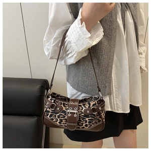 Close-up of leopard print baguette bag with brown faux leather trim and silver metal buckle