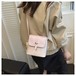 Close-up of pink crossbody bag featuring heart-shaped lock and cute cartoon cat print