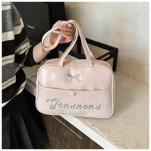 Close-up of a pink patent leather backpack featuring a stylish bow and brand embroidery