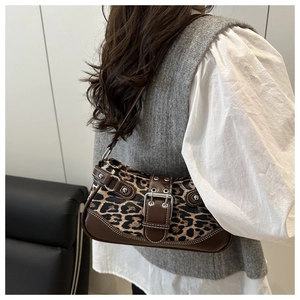 Close-up of leopard print shoulder bag with silver metal eyelets and leather strap detail