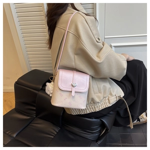 Back view of pink and white mini shoulder bag with heart buckle and plush ball charm