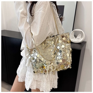 Close-up of golden sequin bucket bag with pearl bow charm and chain strap detail