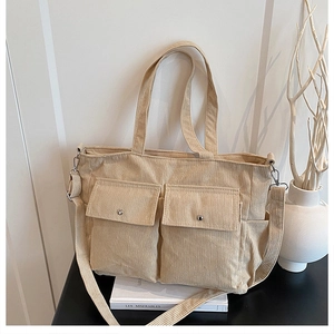 Detailed view of beige corduroy tote bag with dual front pockets and adjustable strap