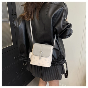 Detail of mini crossbody bag with heart buckle and cute cat pattern on textured PU leather