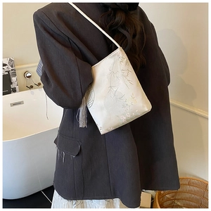 Detalle de bolso tipo cubo de estilo chino con estampados florales y borla de seda