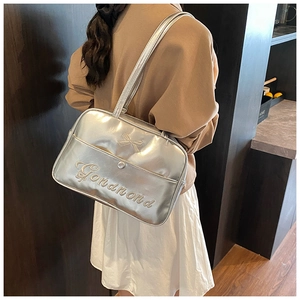 Detailed view of metallic silver tote bag with bow accent and branded texture