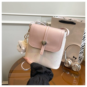 Detail of pink and white bucket bag with heart metal lock and plush charm accessory