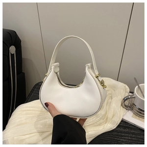 Detail of white half-moon bag featuring premium leather texture and gold metal zipper
