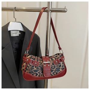 Detailed leopard print canvas bag with red leather trim and metallic buckle design
