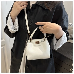 Detail of white lychee pattern leather bag with golden square twist lock on black jacket