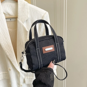Mini black denim handbag with contrast stitching and brown leather patch details
