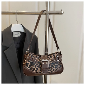 Detailed view of leopard print shoulder bag with silver buckle and metallic rivet accents