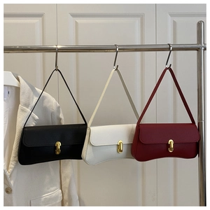 Three leather baguette bags in black, beige, and wine red with gold metal clasps