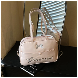 Detail of pink bow embroidery and metallic buckle pocket on glossy PU leather handbag