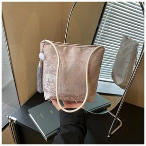 Detalle de la tela jacquard rosa champán y borla tradicional en un bolso tipo cubo