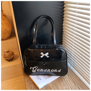 Detail of glossy black backpack featuring white bow accent and Gonamond embroidery