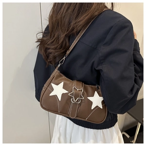 Detail of vintage brown pebble leather shoulder bag featuring white star patch and metal buckle
